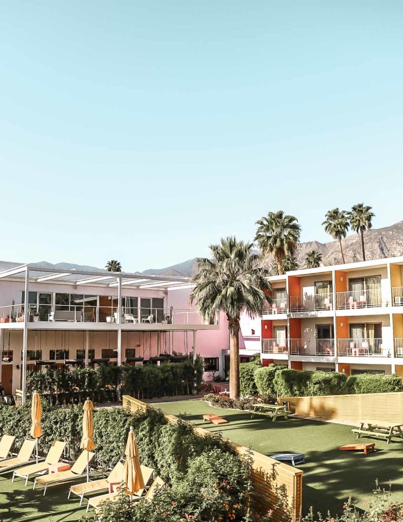 Colorful courtyard featuring lounge chairs and patio games at the Saguaro Hotel in Palm Springs, California.